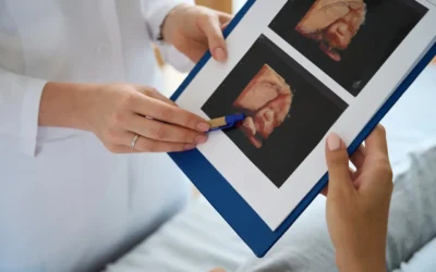 Medical professional showing 3D ultrasound images to an expectant parent, highlighting prenatal bonding and baby imaging details.